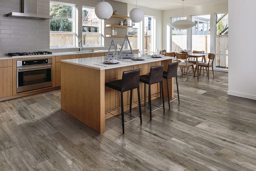 Modern kitchen design featuring a large island, wooden cabinets, and stylish bar stools.