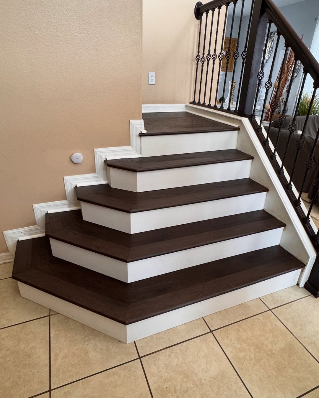 Modern wooden staircase with white trim and tile flooring. Elegant design in home interior.