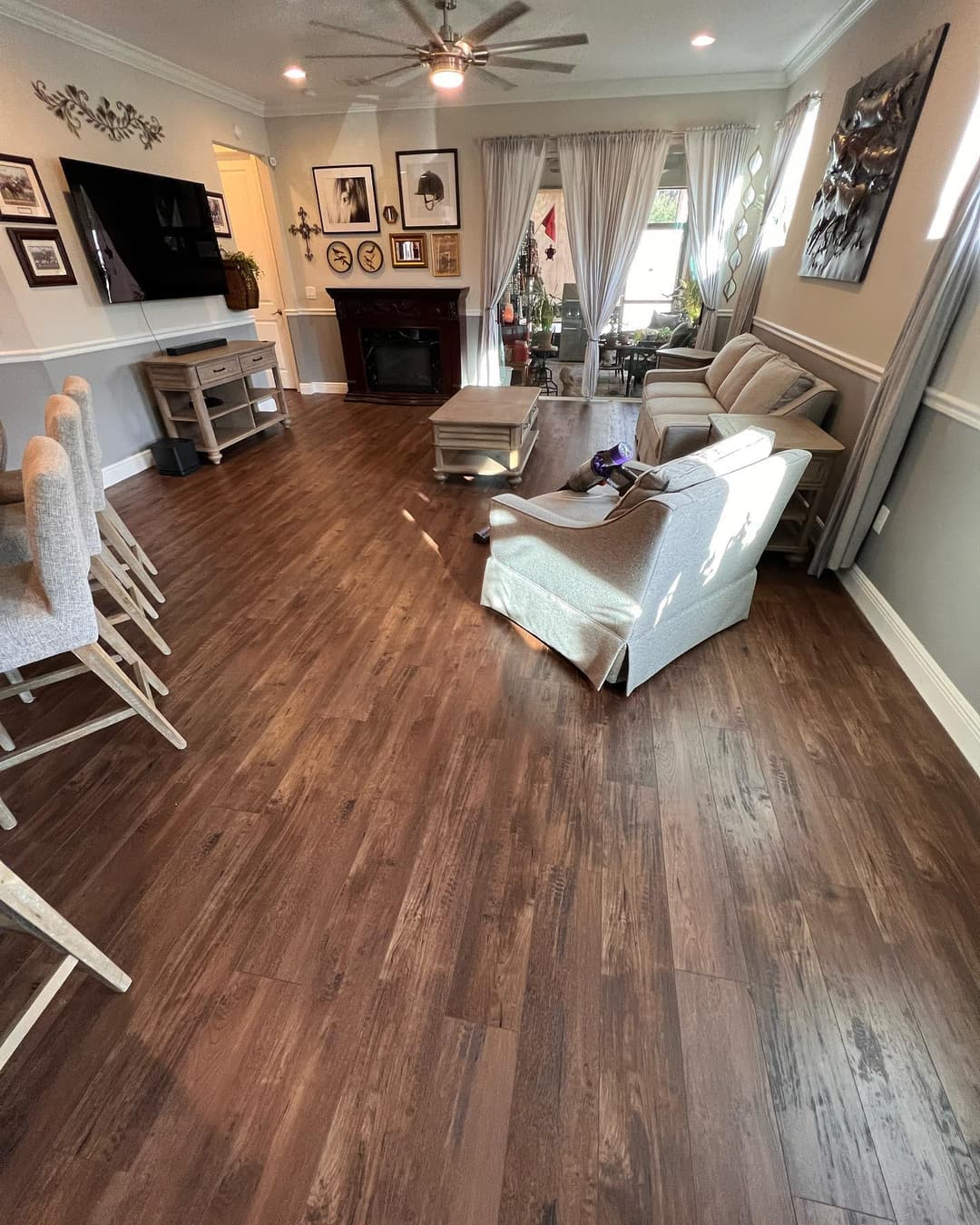 Spacious living room with hardwood floors, modern furniture, and decorative wall art.